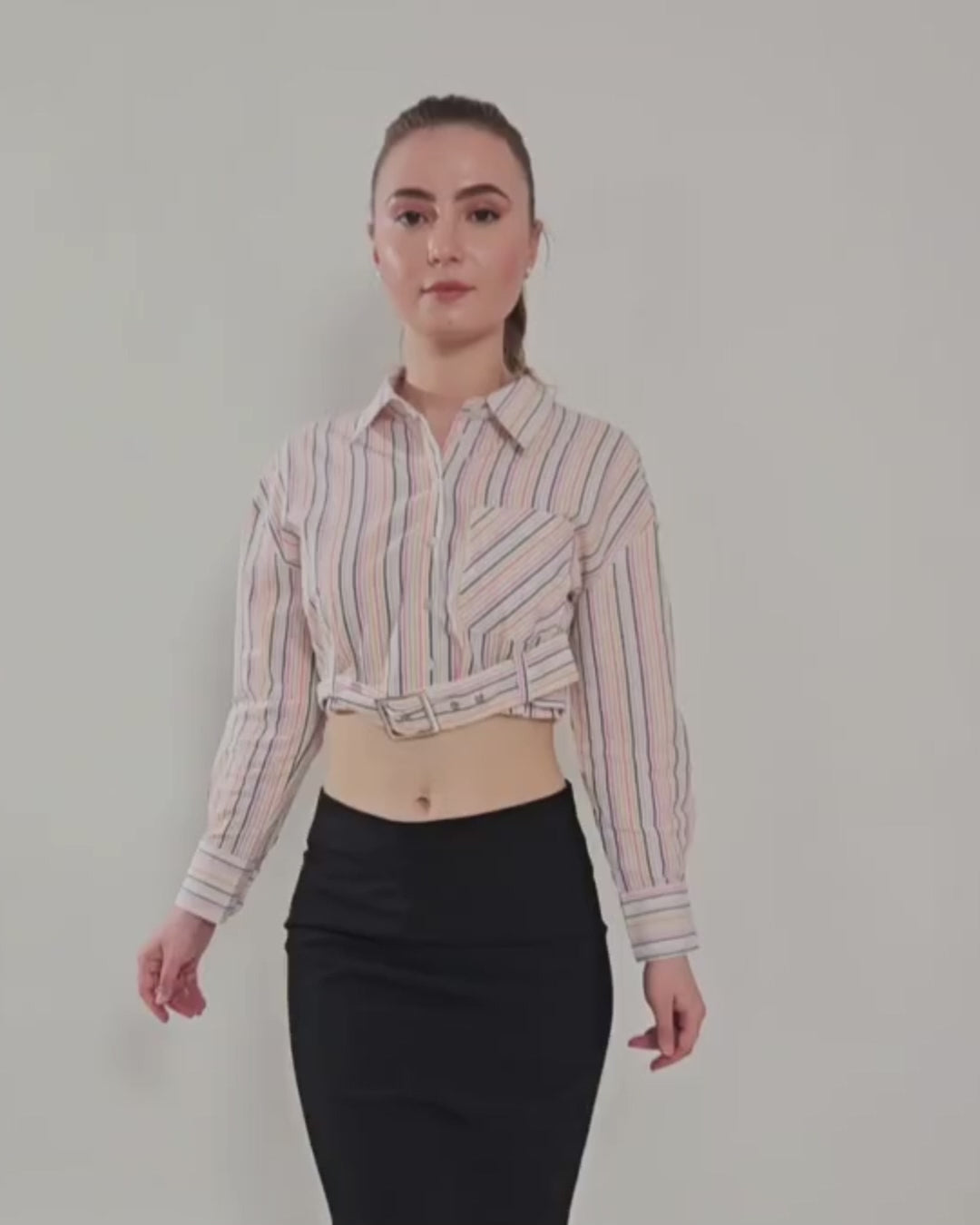 Model wearing a belted cropped shirt with long sleeves, classic point collar, and button-down front