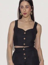 Model in motion wearing 'Harper' cropped waistcoat and matching shorts. A stylish, buttoned sleeveless top sewing pattern for a chic look.