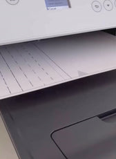Printer with paper tray open, showing printing paper and a printed pattern or document