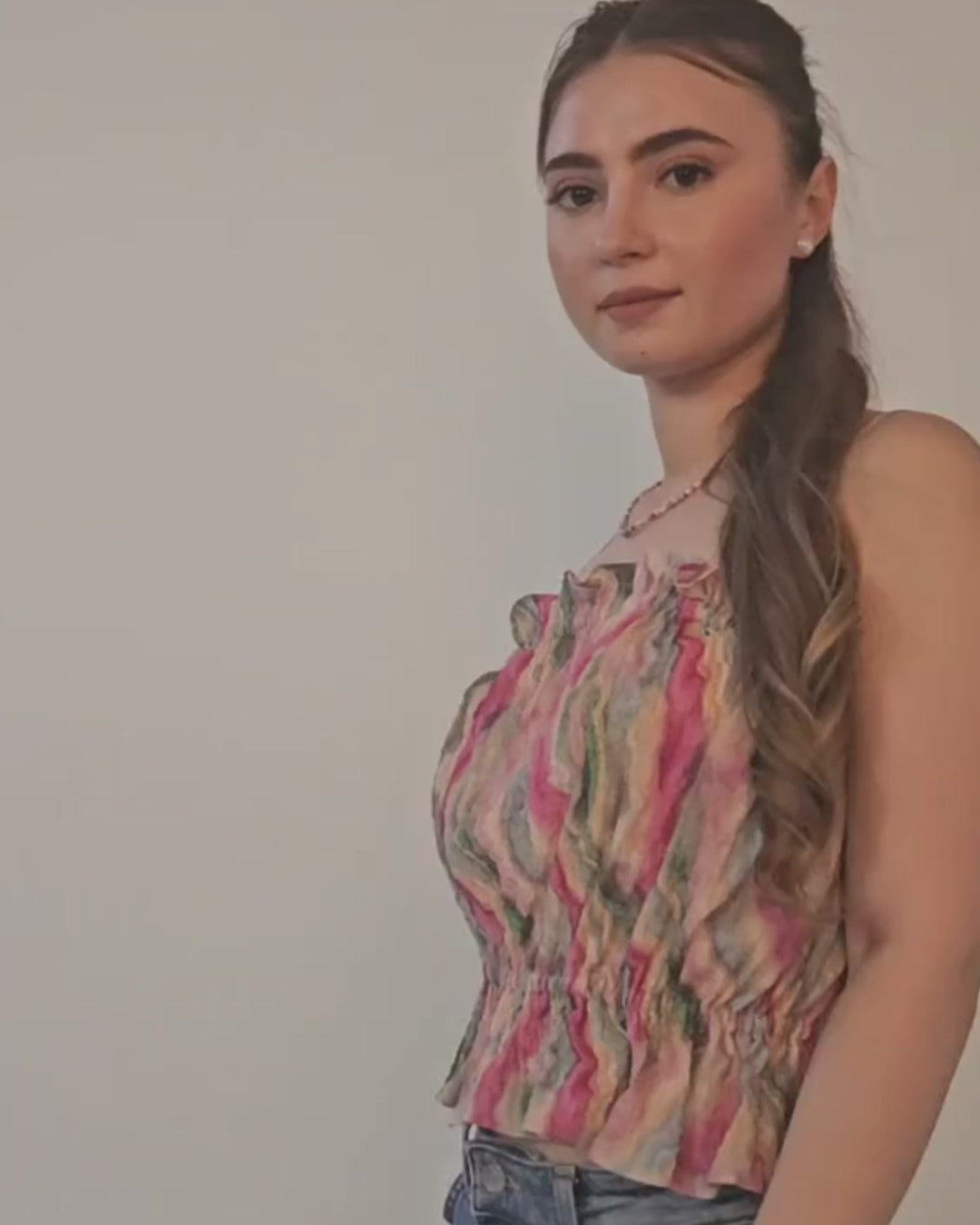 Woman wearing colorful sleeveless ruffle top with gathered details