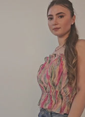 Woman wearing colorful sleeveless ruffle top with gathered details